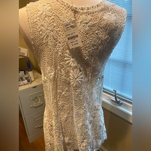 Lacey open top.  Perfect over a tank.  Would look great with a bathing suit too